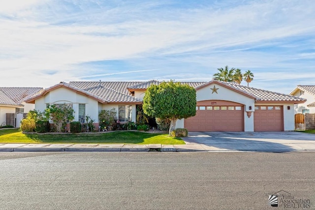 mediterranean / spanish home with a garage and a front lawn