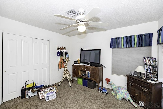 interior space with a textured ceiling, ceiling fan, and a closet