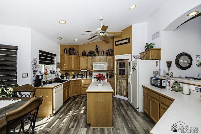 kitchen featuring lofted ceiling, sink, a center island, dark hardwood / wood-style floors, and white appliances