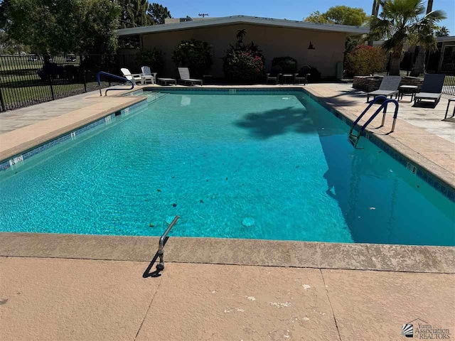 community pool featuring fence and a patio