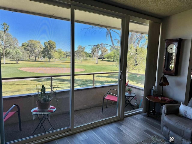 sunroom / solarium featuring view of golf course and plenty of natural light