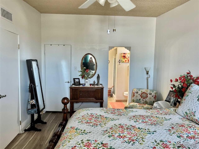 bedroom with visible vents, a ceiling fan, connected bathroom, a textured ceiling, and wood finished floors