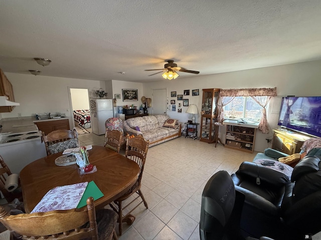 dining area featuring ceiling fan, sink, and a textured ceiling