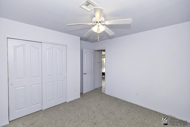 unfurnished bedroom with ceiling fan, light carpet, and a closet