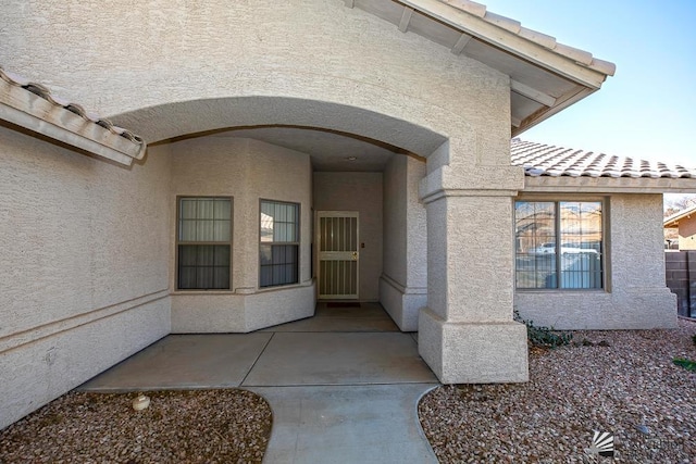 view of exterior entry with a patio