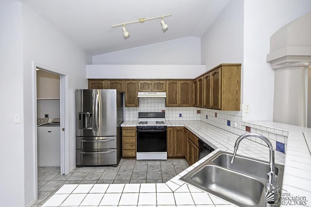 kitchen featuring sink, stainless steel fridge, backsplash, gas stove, and tile countertops