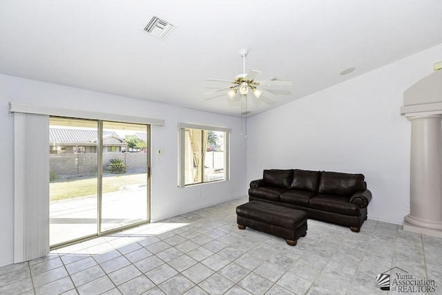 living room featuring ornate columns, light tile patterned floors, and ceiling fan