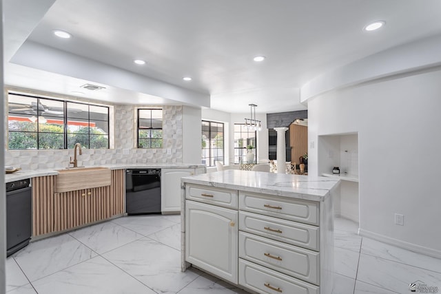 kitchen featuring dishwasher, white cabinetry, sink, backsplash, and hanging light fixtures