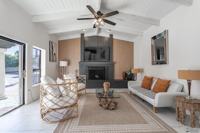 living room featuring ceiling fan, wooden walls, a fireplace, and lofted ceiling with beams