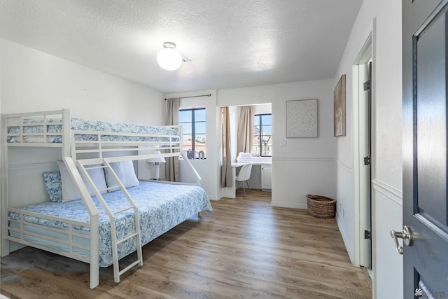 bedroom featuring hardwood / wood-style floors and a textured ceiling