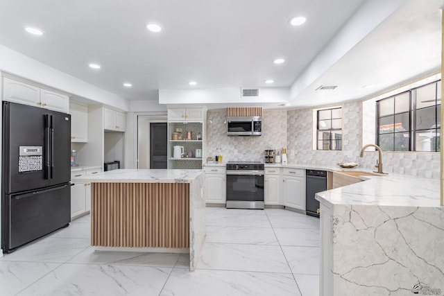 kitchen with light stone countertops, appliances with stainless steel finishes, decorative backsplash, white cabinets, and sink