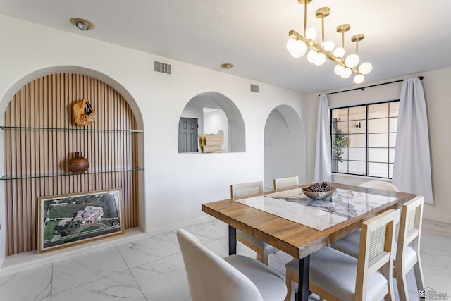 dining space with an inviting chandelier and a textured ceiling