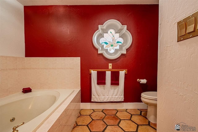 bathroom featuring a relaxing tiled tub, toilet, and tile patterned flooring