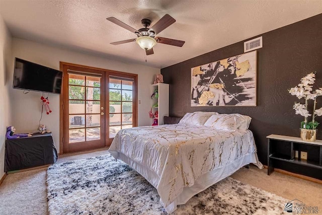 carpeted bedroom with ceiling fan, access to outside, french doors, and a textured ceiling