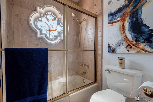 bathroom featuring bath / shower combo with glass door and toilet