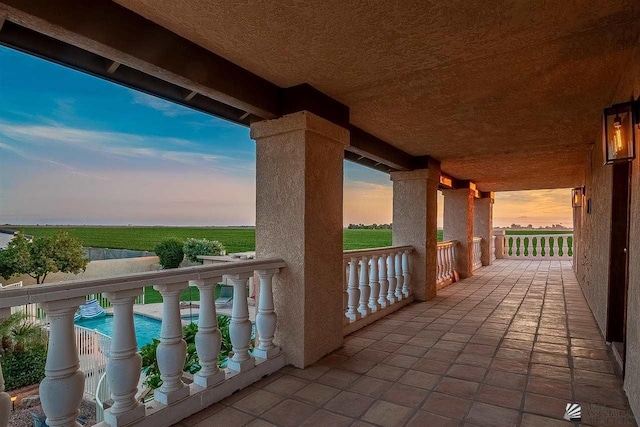 patio terrace at dusk featuring a balcony