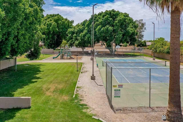 view of tennis court with a yard and a playground