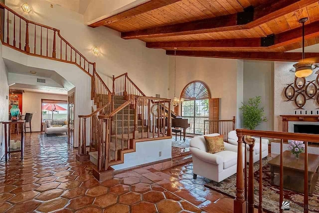 interior space with beam ceiling, wood ceiling, and a high ceiling