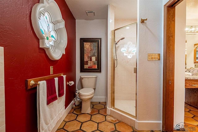 bathroom with vanity, a shower with shower door, tile patterned floors, and toilet