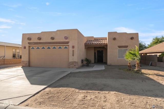 pueblo revival-style home with a garage