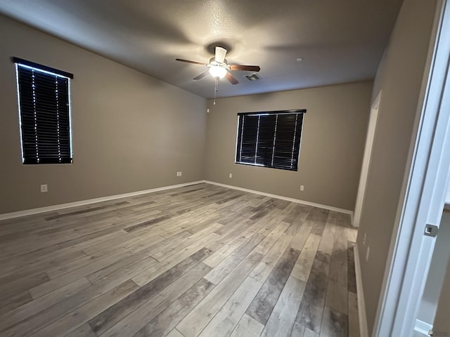 unfurnished room with ceiling fan and light wood-type flooring