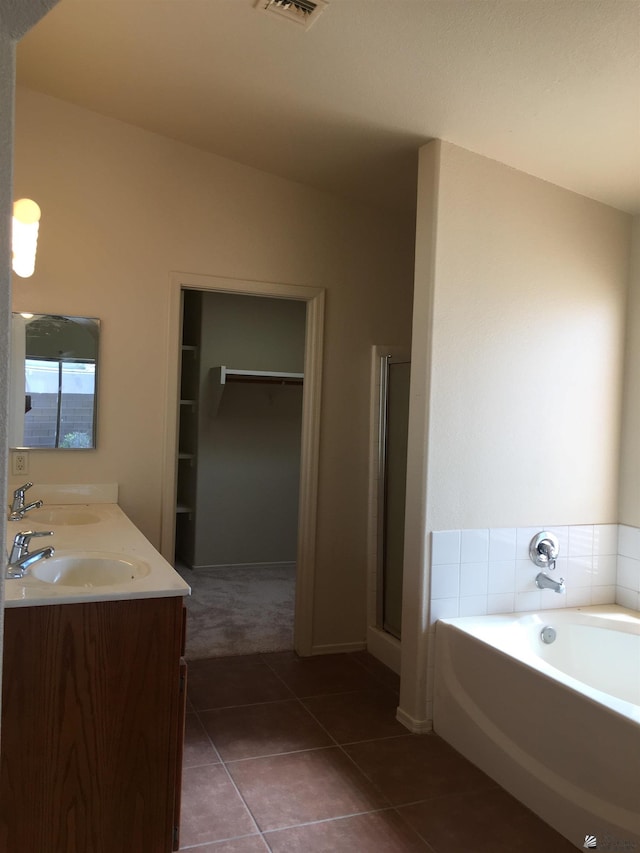 bathroom featuring tile patterned flooring, vanity, and shower with separate bathtub