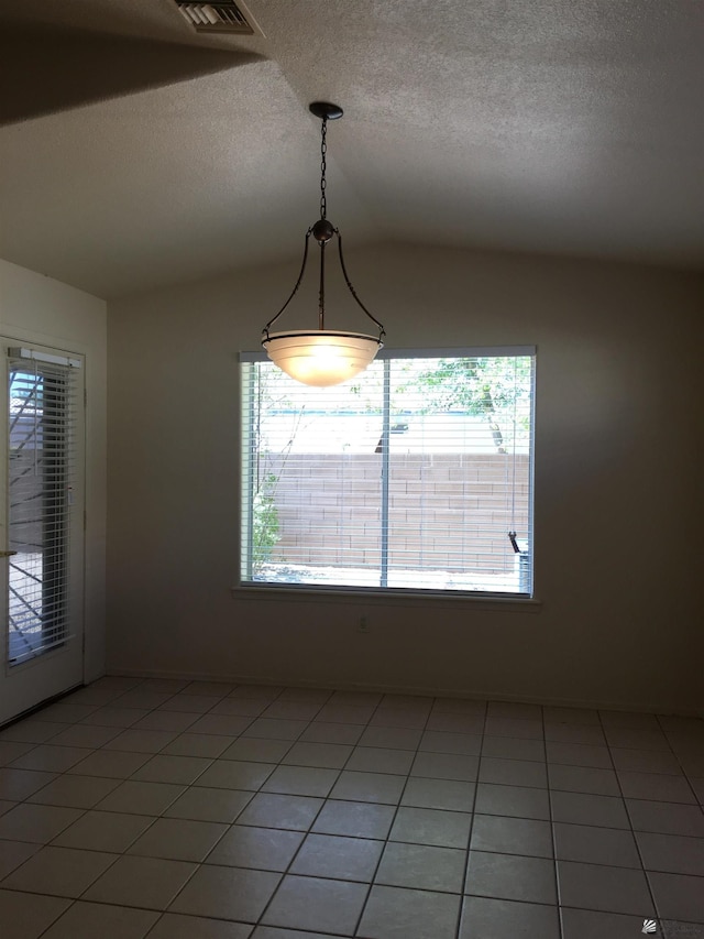 empty room with tile patterned flooring and lofted ceiling