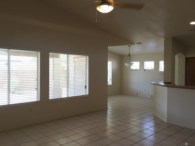 tiled spare room featuring plenty of natural light, ceiling fan, and vaulted ceiling