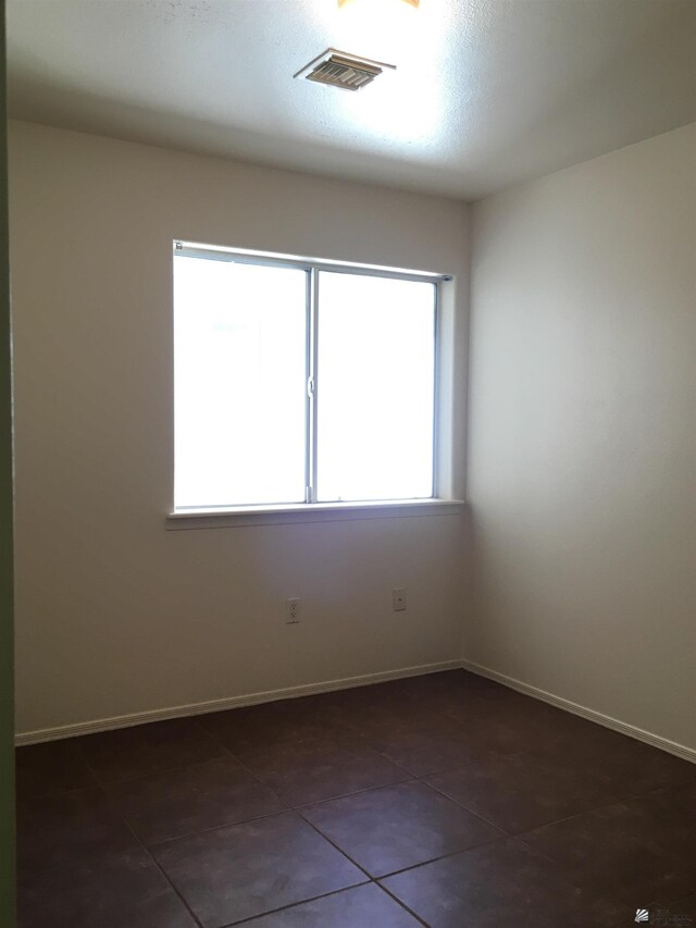 spare room with dark tile patterned flooring