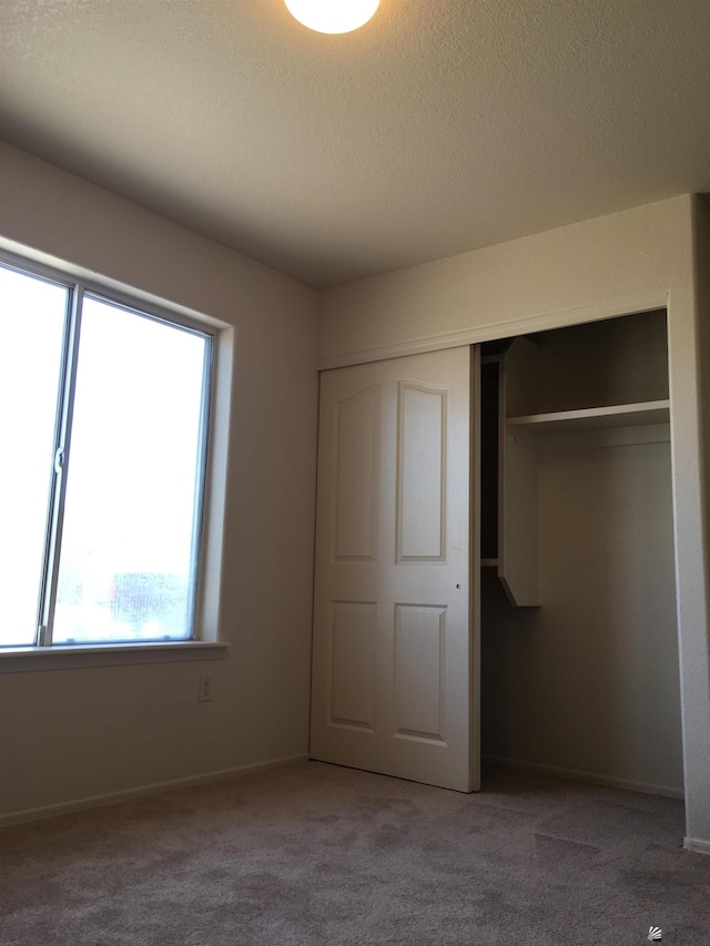 unfurnished bedroom with carpet floors and a closet