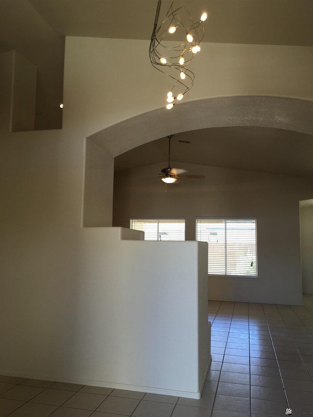 corridor featuring tile patterned flooring, a notable chandelier, and vaulted ceiling