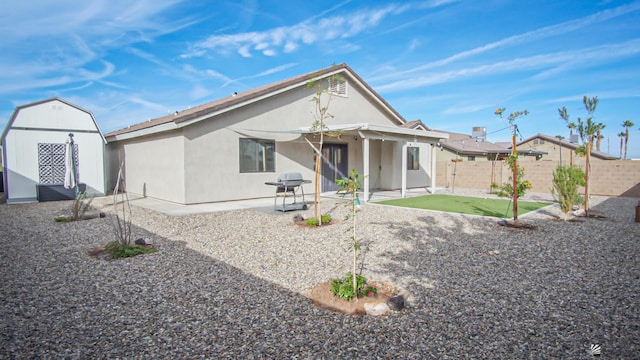 back of property featuring a storage unit and a patio area