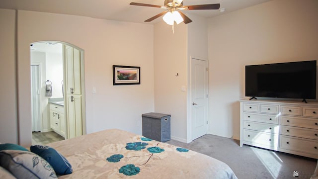 carpeted bedroom featuring connected bathroom and ceiling fan