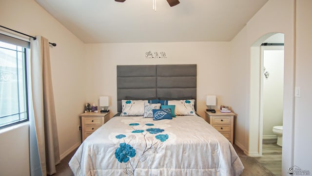 bedroom with ensuite bathroom, light hardwood / wood-style flooring, and ceiling fan