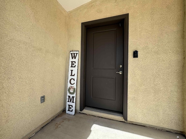 view of exterior entry with stucco siding