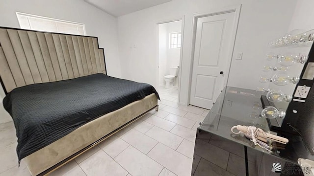 bedroom with tile patterned floors, a dry bar, ensuite bathroom, and lofted ceiling