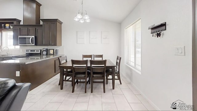 dining room with light tile patterned floors, a notable chandelier, baseboards, and lofted ceiling