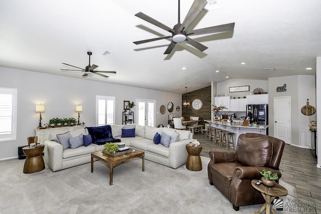 carpeted living room featuring vaulted ceiling and ceiling fan