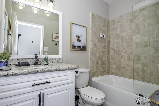 full bathroom featuring tiled shower / bath combo, vanity, and toilet