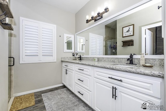 bathroom with hardwood / wood-style flooring, vanity, and an enclosed shower