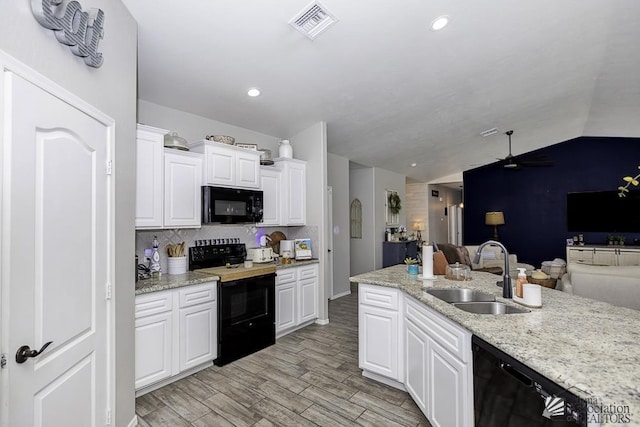 kitchen featuring sink, black appliances, light wood-type flooring, light stone countertops, and white cabinets