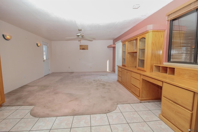 unfurnished living room with light tile patterned floors and ceiling fan