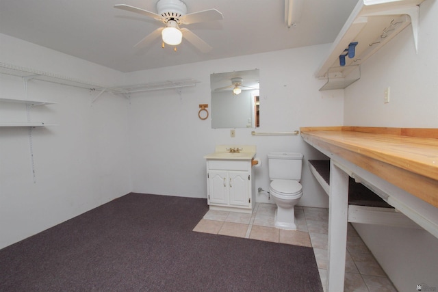 bathroom featuring tile patterned flooring, vanity, ceiling fan, and toilet