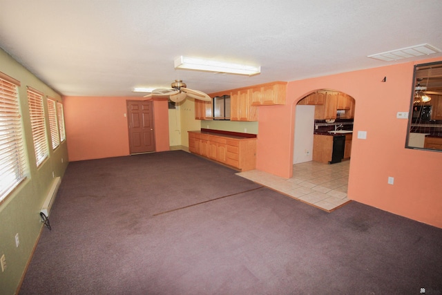 unfurnished living room featuring light colored carpet, baseboard heating, and ceiling fan