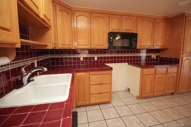 kitchen with decorative backsplash, light tile patterned floors, and sink