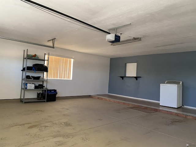 garage with baseboards, washer / clothes dryer, and a garage door opener