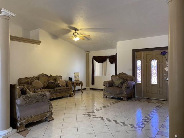 living area with decorative columns, a ceiling fan, light tile patterned flooring, vaulted ceiling, and baseboards