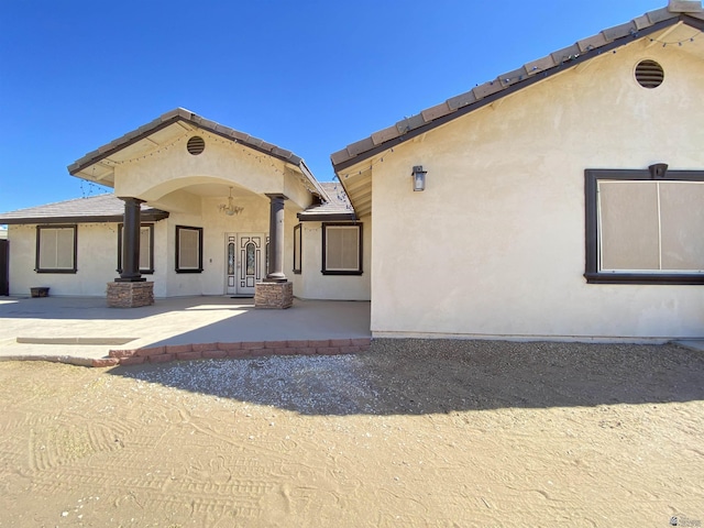 rear view of house featuring a patio and stucco siding