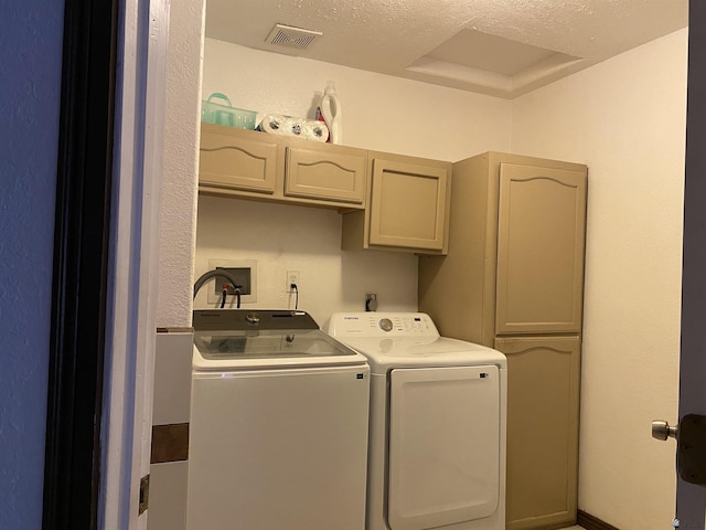 laundry room featuring visible vents, washing machine and dryer, and cabinet space