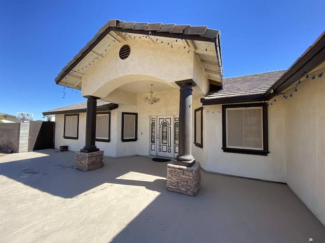 back of property with fence, a patio, and stucco siding